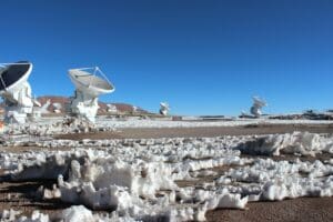 a large array of satellite dishes sitting on top of a sandy beach