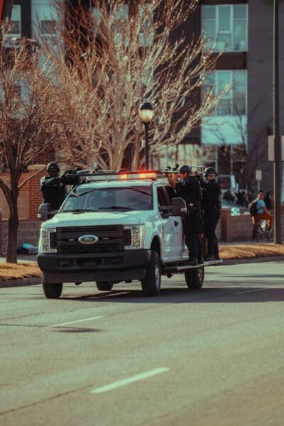 Swat team riding in a truck with guns.